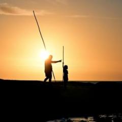 man and child fishing at sunset